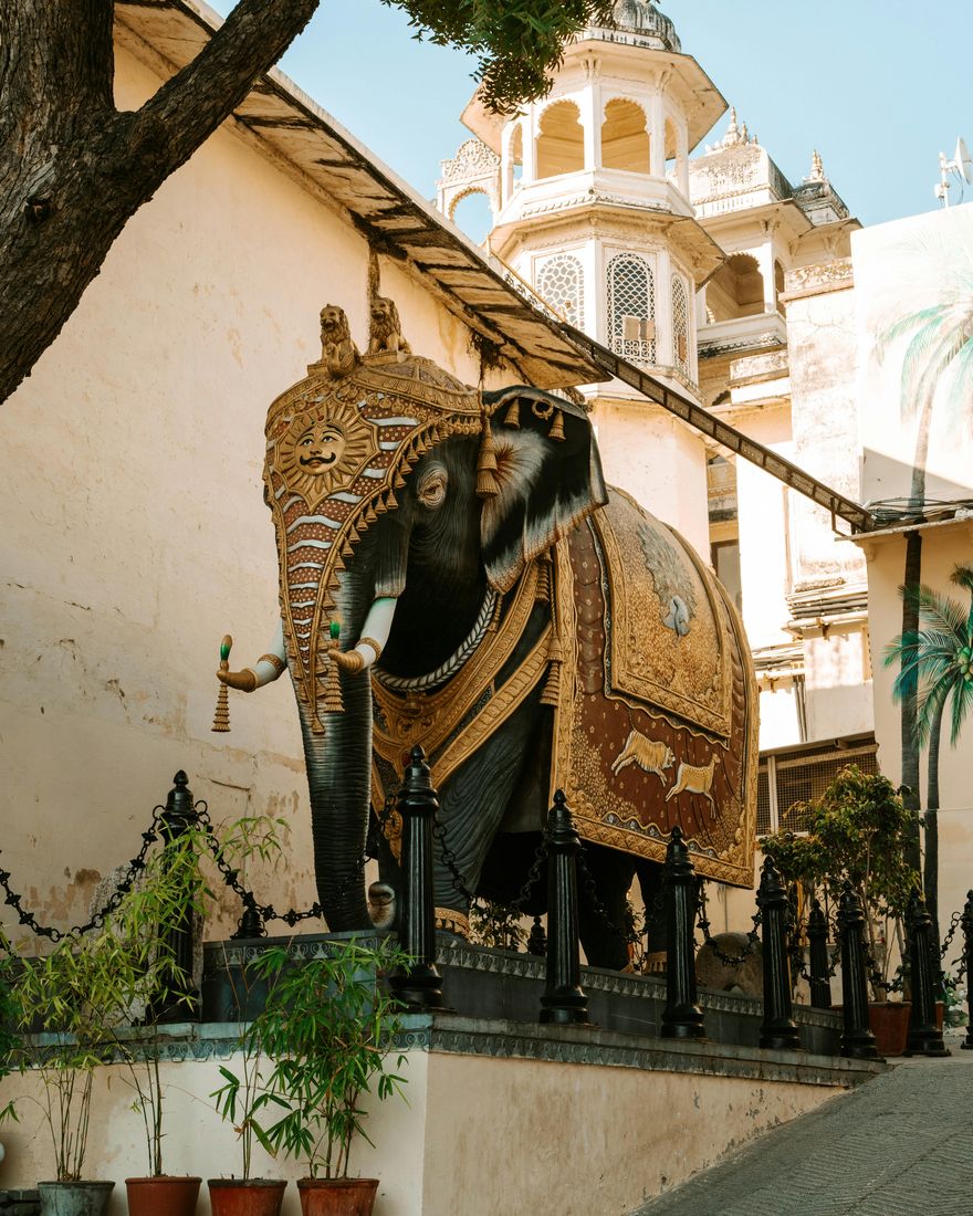 Estatua de un elefante ceremonial pintado junto a un palacio de Udaipur