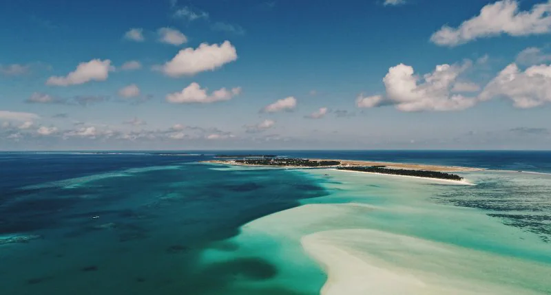 Vista aérea de un atolón de las Maldivas con laguna turquesa y banco de arena