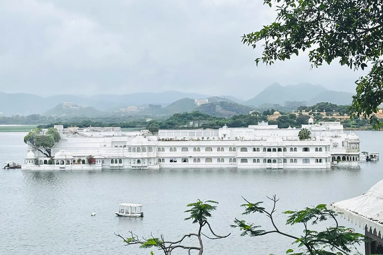El Taj Lake Palace, blanco sobre el lago Pichola, con las colinas de Udaipur al fondo