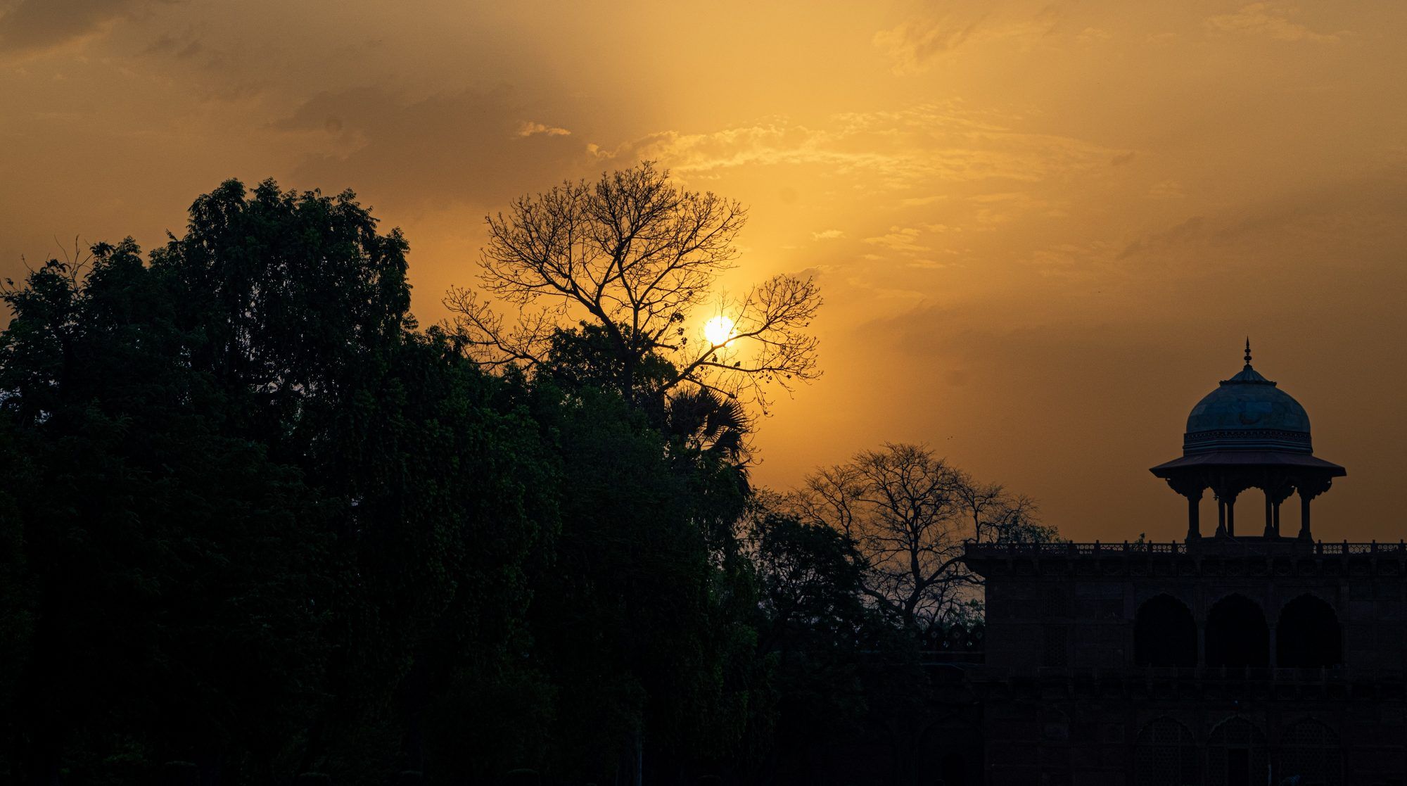 Pabellón mogol recortado contra el cielo al atardecer en la India
