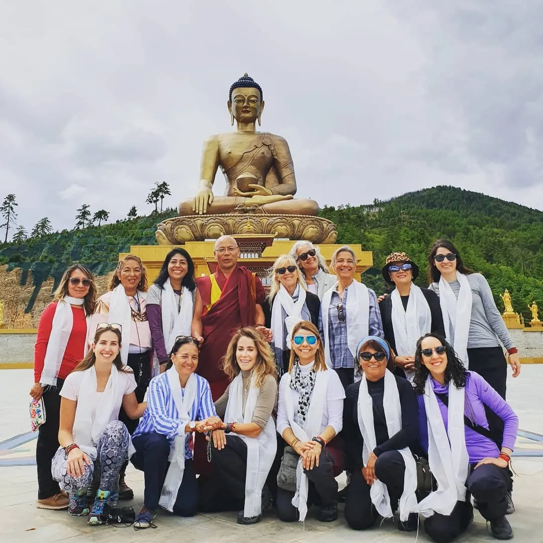 Grupo de viajeras con un monje budista ante la gran estatua dorada del Buda Dordenma en Bután