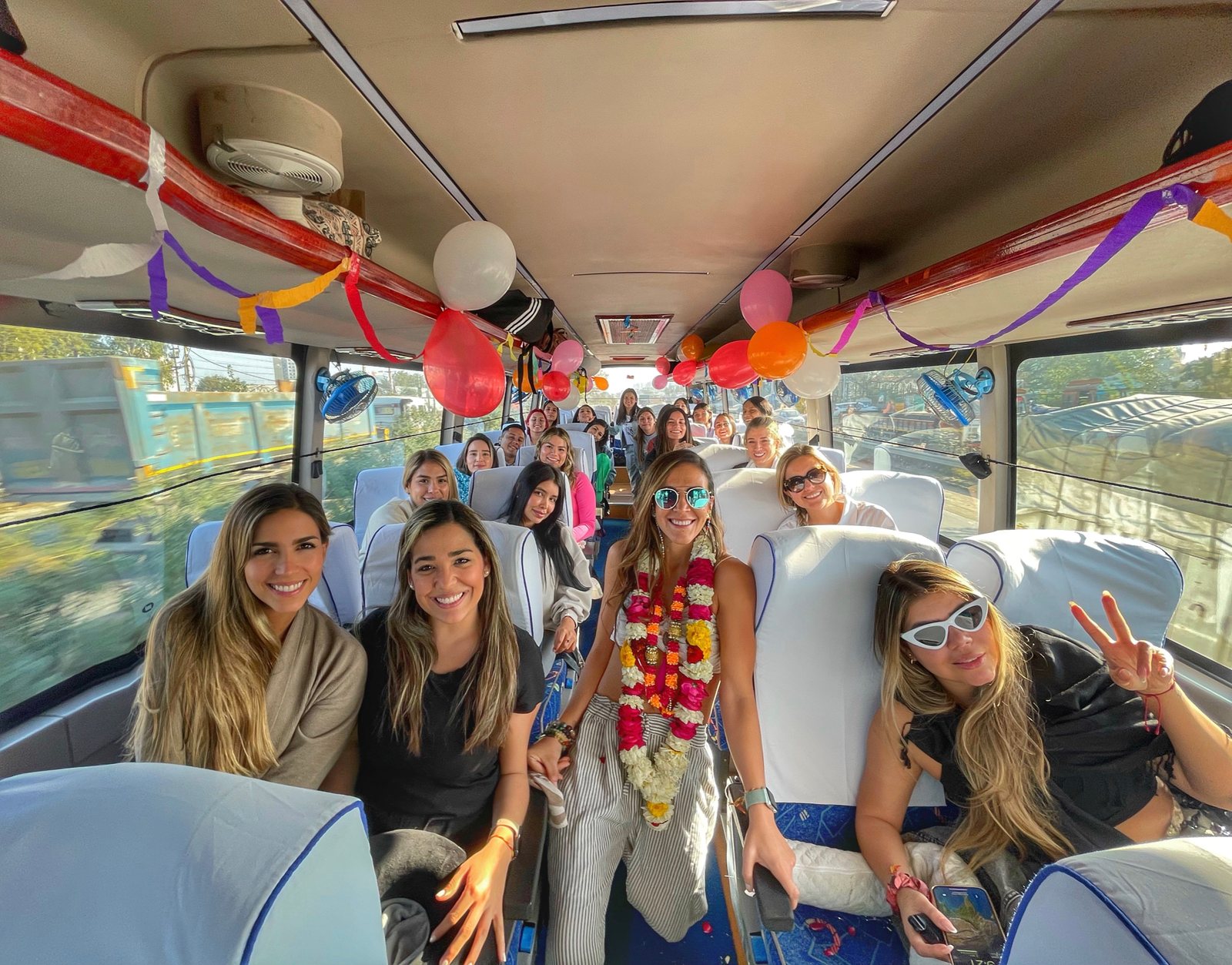 Viajeras sonrientes en un autobús decorado con globos