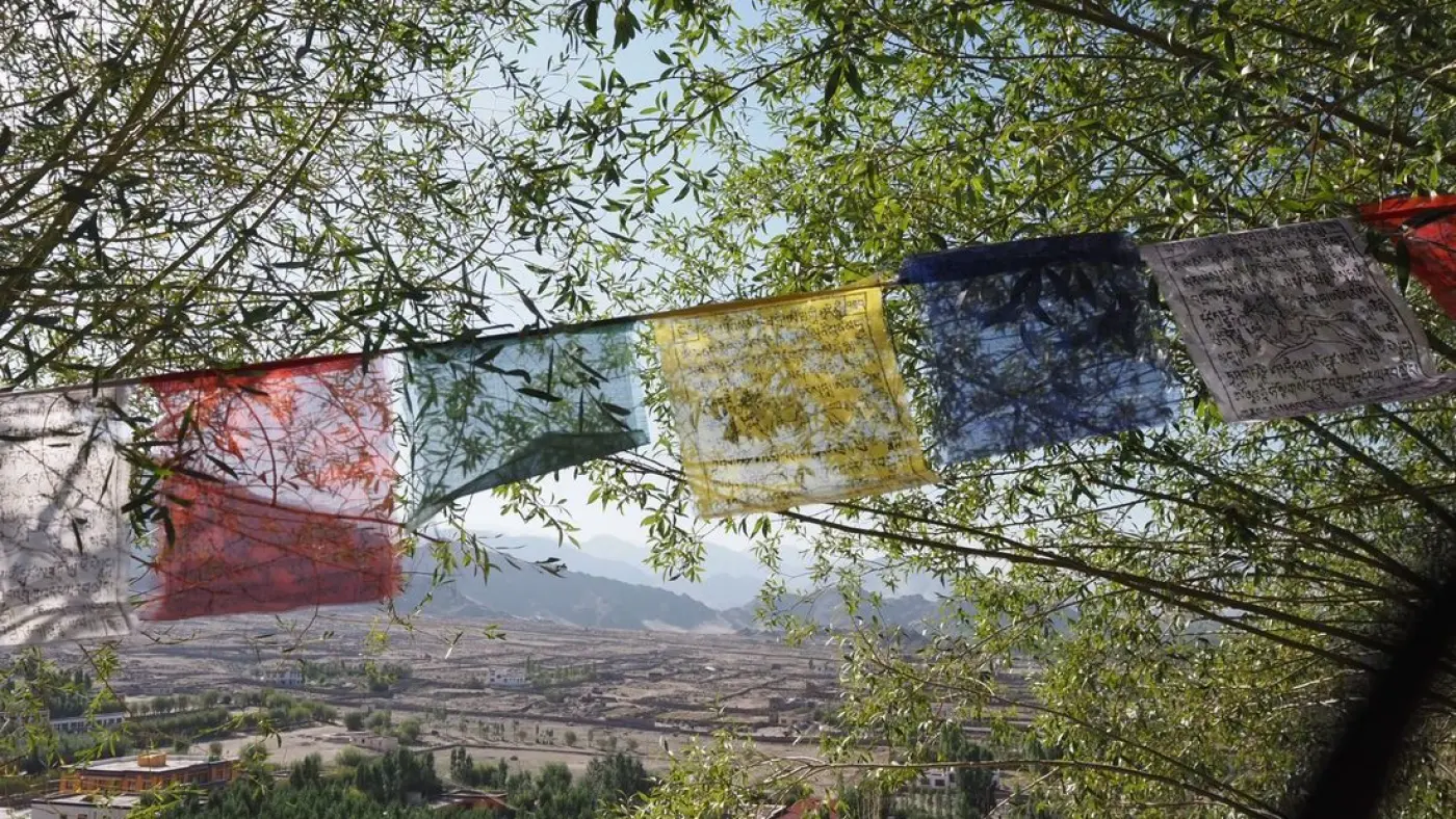 Banderas de oración tibetanas ondean sobre los tejados de Leh, Ladakh