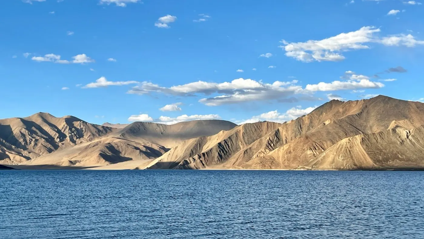 Lago de montaña de aguas azules entre laderas ocres de Ladakh