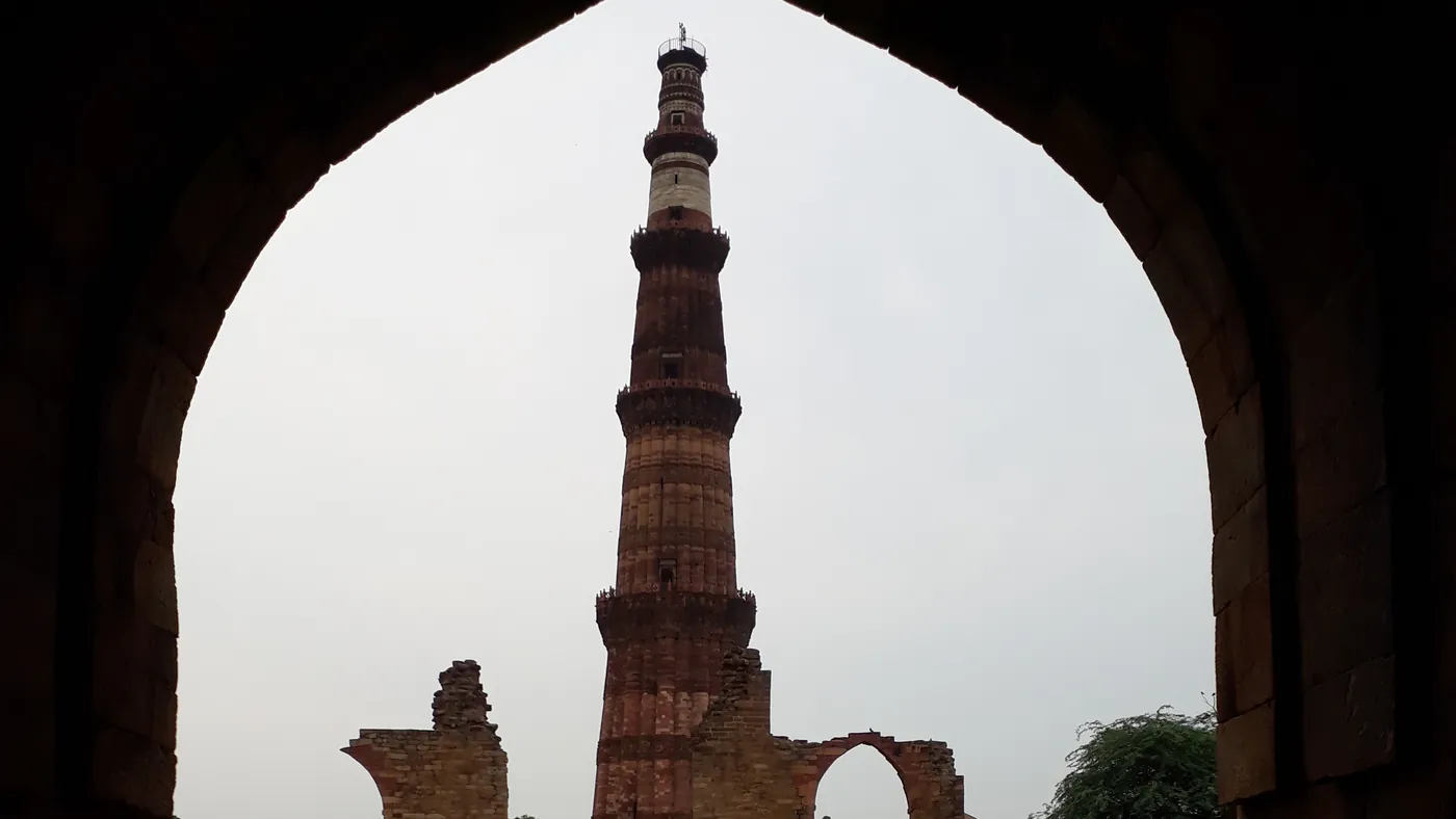 El Qutb Minar enmarcado por un arco de piedra, Delhi